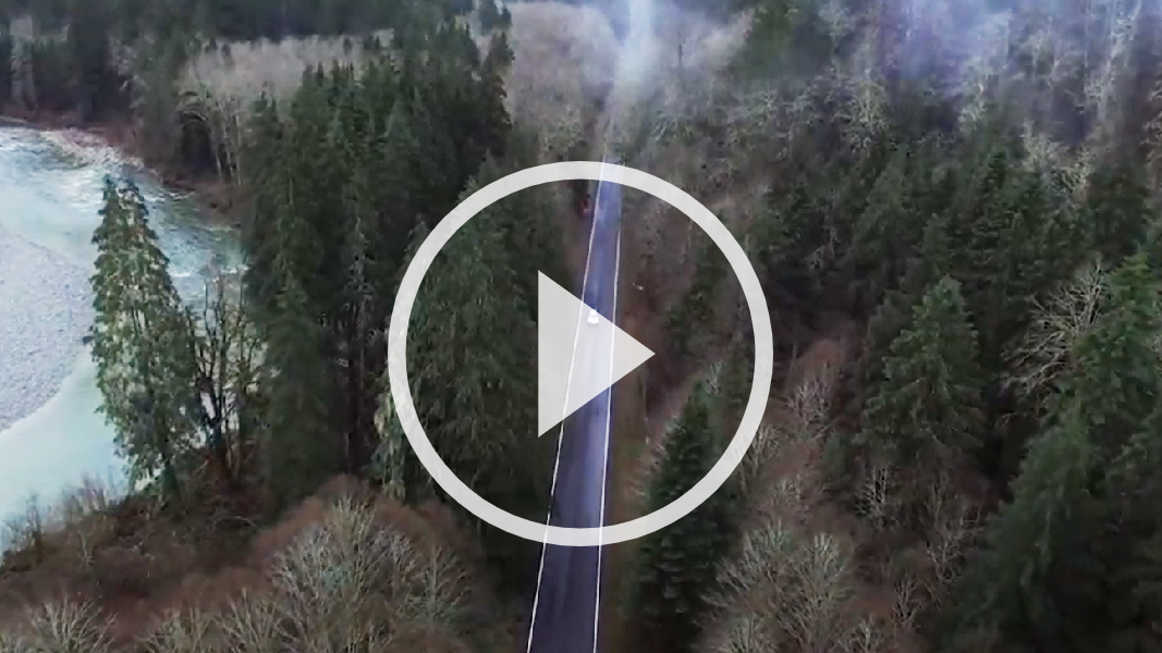 aerial shot of highway running through forest